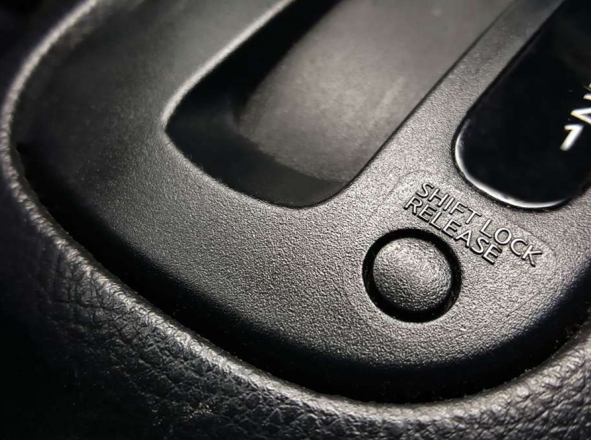 ¿Cuál es el funcionamiento del botón Shift Lock en un auto?