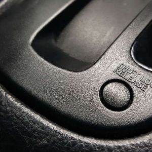 ¿Cuál es el funcionamiento del botón Shift Lock en un auto?